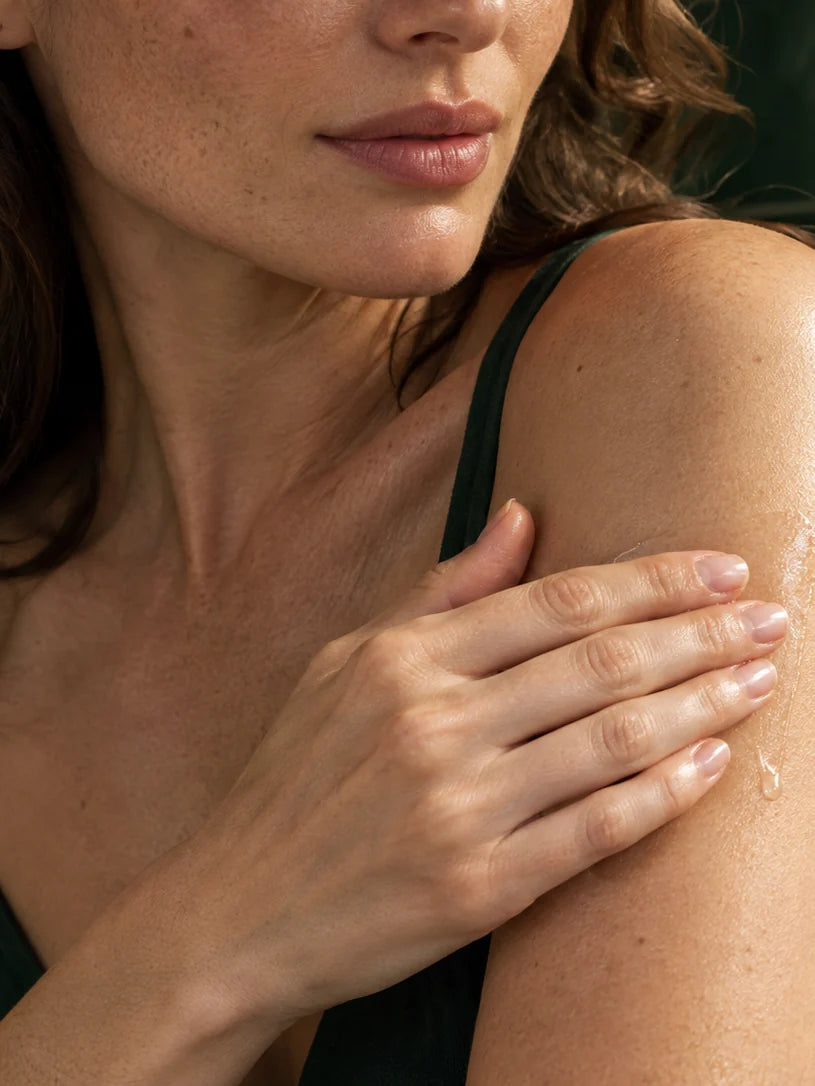 Woman holding the Bioactive Herbal Oil at her neck.